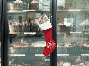 Red stocking with beef in it in front of freezer with Oak Barn Beef logo 