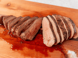 Tri Tip beef Roast cooked and on a cutting board with a white background. Photo will make your mouth water.